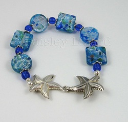 Blue glass beaded bracelet with silver starfish clasp.