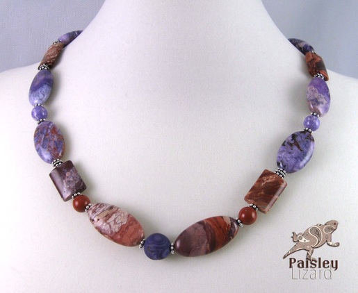 red and purple gemstone necklace on display