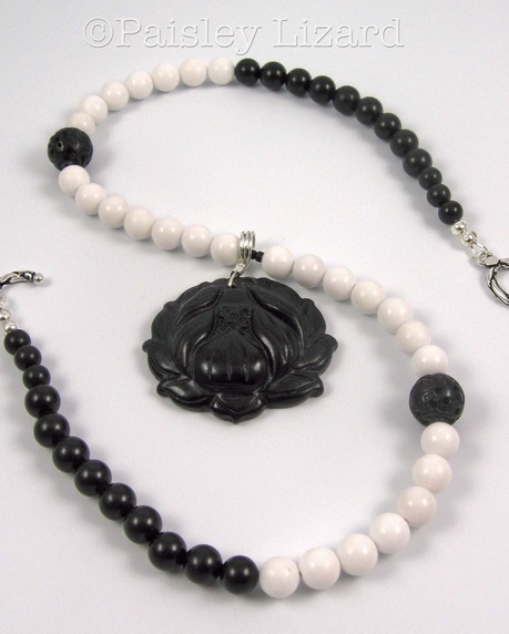 Picture of black lotus pendant on black and white beaded necklace