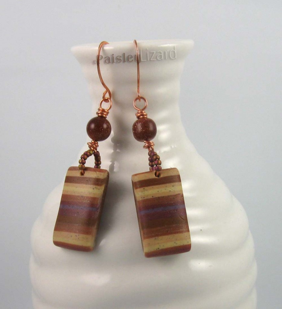 polymer clay earrings displayed on bottle