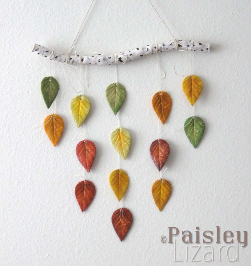 Polymer clay birch branch with stands of fall color leaves hanging on wall