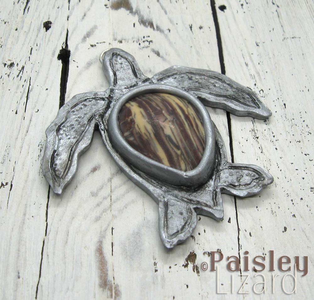 Faux silver turtle pendant with faux petrified wood cabochon.