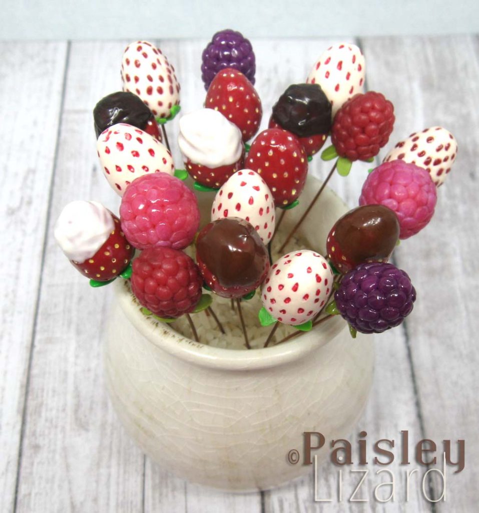 Polymer clay berry headpins in white vase.