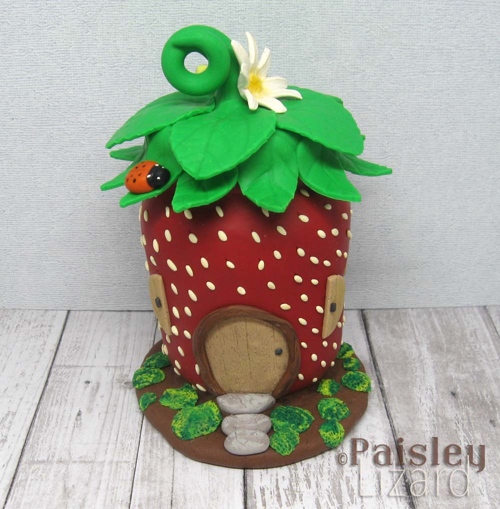 Strawberry fairy house glass jar covered with polymer clay