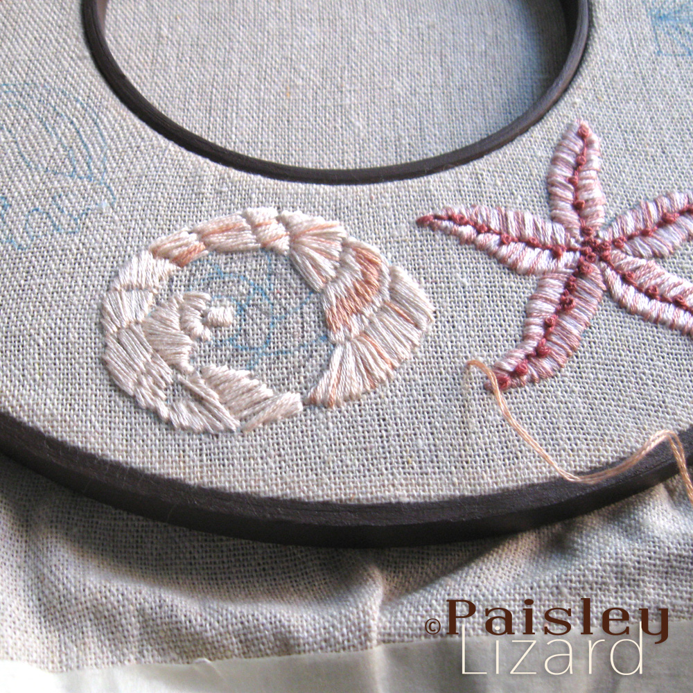 In progress seashell embroidery on linen fabric.